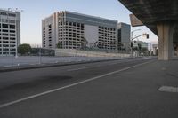 the empty city highway has a bunch of cars driving down it and buildings on both sides