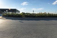 a parking lot with lots of trees on both sides of the road and a billboard over it