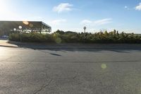 a parking lot with lots of trees on both sides of the road and a billboard over it