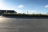 a parking lot with lots of trees on both sides of the road and a billboard over it