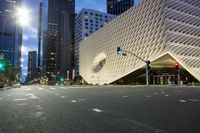 the city buildings are all built using curved, glass panels on them and red traffic lights are shown
