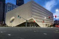 the city buildings are all built using curved, glass panels on them and red traffic lights are shown