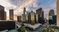 an image of a very high rise city at sunset with lots of skyscrapers around