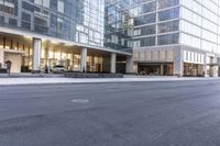 a fire hydrant in the middle of an empty city street with people walking on the sidewalk and an office building in the background