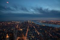 a view of a city at night from the top of a building with a light on