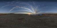 the sun is shining behind the water and some clouds over some desert land in a circular pattern