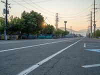 an empty street in front of a large red brick building on the other side of the road is a street light that has a line for motorists