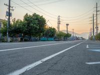 an empty street in front of a large red brick building on the other side of the road is a street light that has a line for motorists