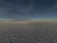 a desert area with a white substance and some clouds in the sky and a person running on the ground