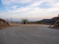 people walk along a winding path at sunset on the ocean in the distance are mountains