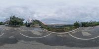 a 360 camera shot showing a ramp and road in the background of some trees, clouds, and buildings