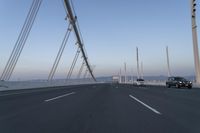 cars drive across an overpass on a bridge that is spanning across the water and mountains