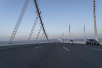 cars drive across an overpass on a bridge that is spanning across the water and mountains