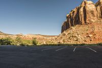 this is a small car parking lot in front of a mountain range with mountains and shrubs
