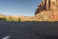 this is a small car parking lot in front of a mountain range with mountains and shrubs