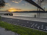 the view of the bay bridge, from the side walk at dusk with painted dots on the pavement