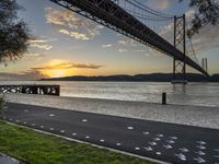 the view of the bay bridge, from the side walk at dusk with painted dots on the pavement