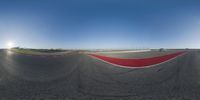 a man on a motorcycle taking a picture of himself and his friends on the other side of a race track