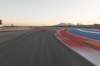 Dawn at the Race Track: A Red Stadium in Clear Sky