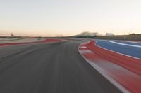 Dawn at the Race Track: A Red Stadium in Clear Sky