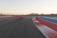 Dawn at the Race Track: A Red Stadium in Clear Sky