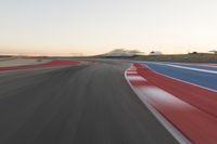 Dawn at the Race Track: A Red Stadium in Clear Sky