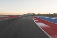 Dawn at the Race Track: A Red Stadium in Clear Sky