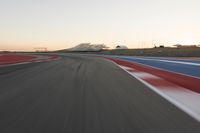 Dawn at the Race Track: A Red Stadium in Clear Sky