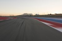 Dawn at the Race Track: A Red Stadium in Clear Sky