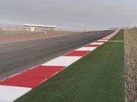 an airport runway next to a field and buildings with a long strip that says silver, red, and white