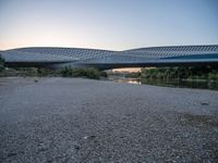 there are two very long bridges that are above the river shore at dusk here, and you can see how close them are