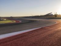 an image of a racetrack with a sunset in the background and a line of red