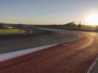 an image of a racetrack with a sunset in the background and a line of red