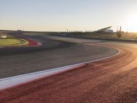 an image of a racetrack with a sunset in the background and a line of red