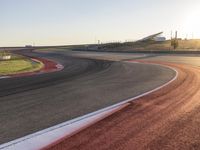 an image of a racetrack with a sunset in the background and a line of red