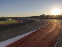 an image of a racetrack with a sunset in the background and a line of red