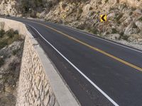 this is the image of a mountain road with trees and rocks on both sides of it