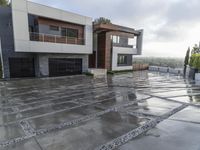 a home with grey concrete and large, well kept yard on a cloudy day in the mountains