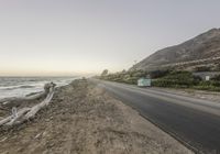 a car driving along the coast during a sunset time in california, usa with rocks and boulders