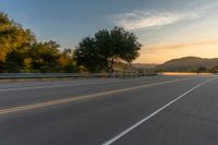 an empty highway that runs through the valley in the sunset and into mountains on either side