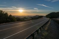 Dawn on a Rural Mountain Road: Sunlight Breaking Through Clouds