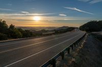 Dawn on a Rural Mountain Road: Sunlight Breaking Through Clouds