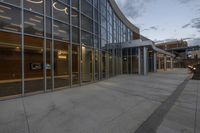 a building with large windows and a sign on the side of it and lights on inside