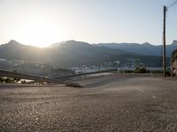 there is a truck parked at the end of a hill next to water and mountains