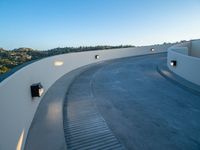 curved stairs are lined around an outside building with bright lights on the walls and cement ground