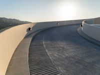 a skateboard is riding on the edge of an urban skate park as the sun goes down