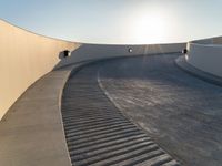 a skateboard is riding on the edge of an urban skate park as the sun goes down