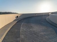 a skateboard is riding on the edge of an urban skate park as the sun goes down