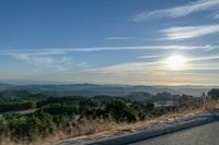 Dawn Sunlight over Highland Landscape with Asphalt Road