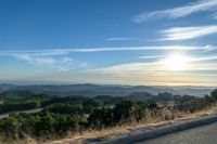 Dawn Sunlight over Highland Landscape with Asphalt Road